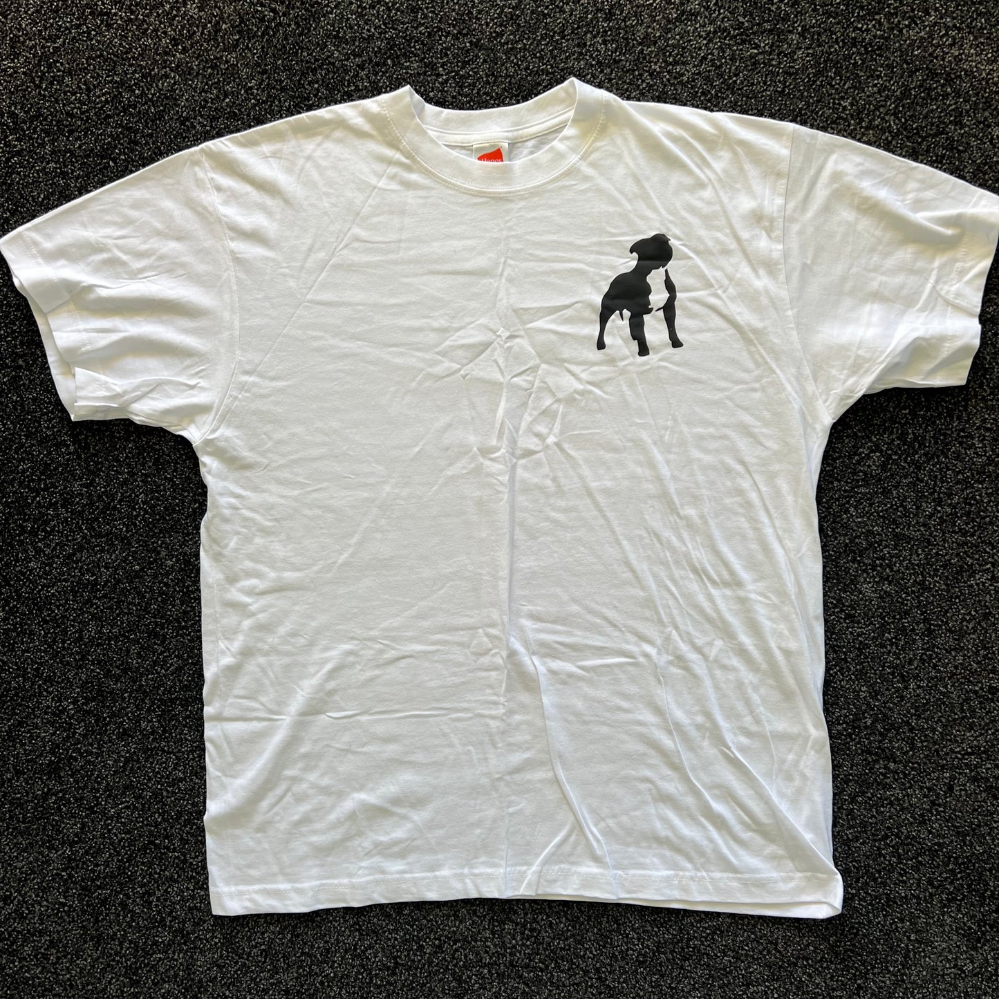 White t-shirt with a black dog graphic on a dark textured surface