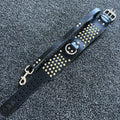 Black leather strap with gold studs and a smiley face design on a textured black background