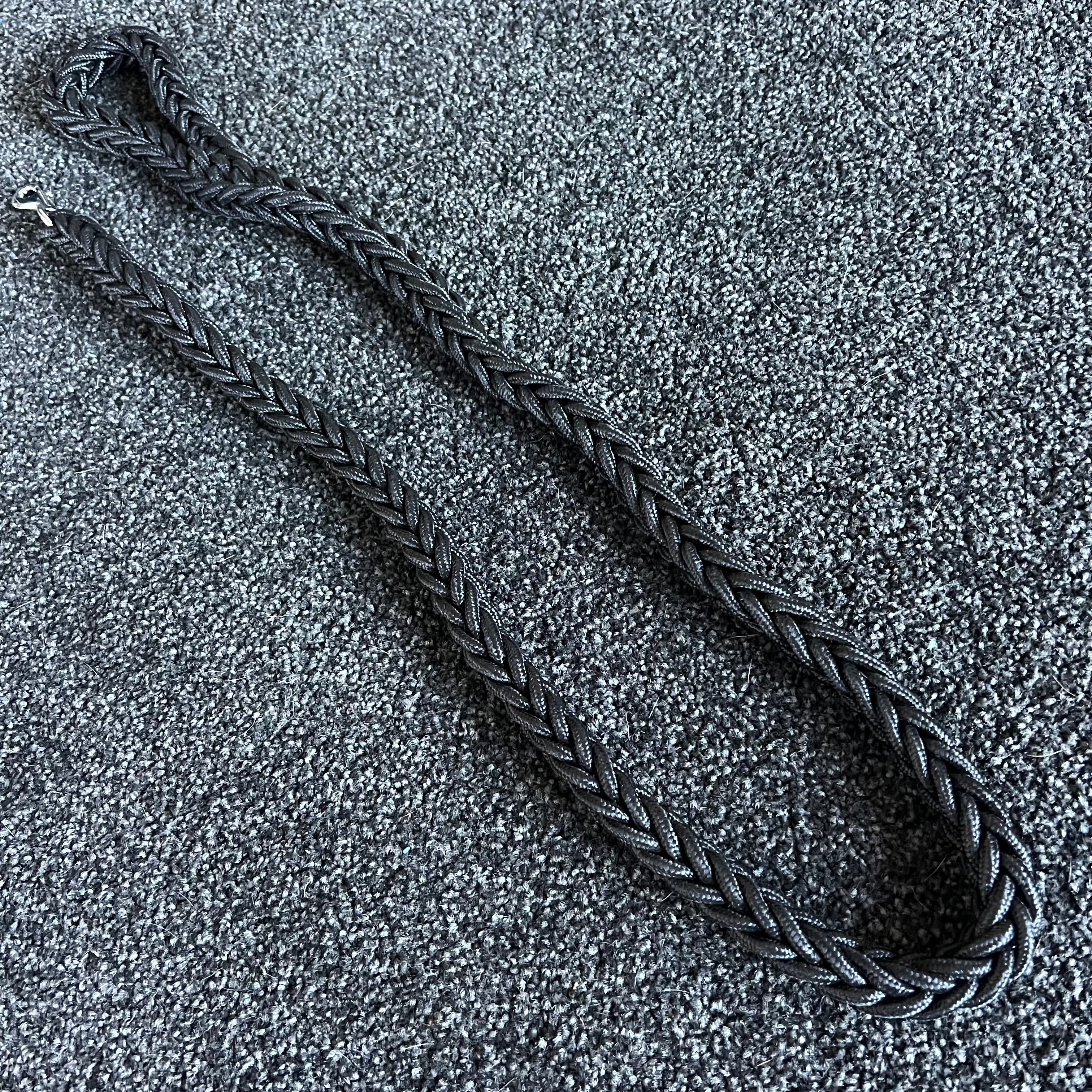 Black braided leash on a textured gray surface