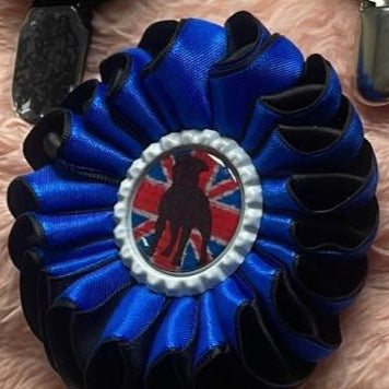 Blue ribbon with a dog silhouette and Union Jack design on a textured surface