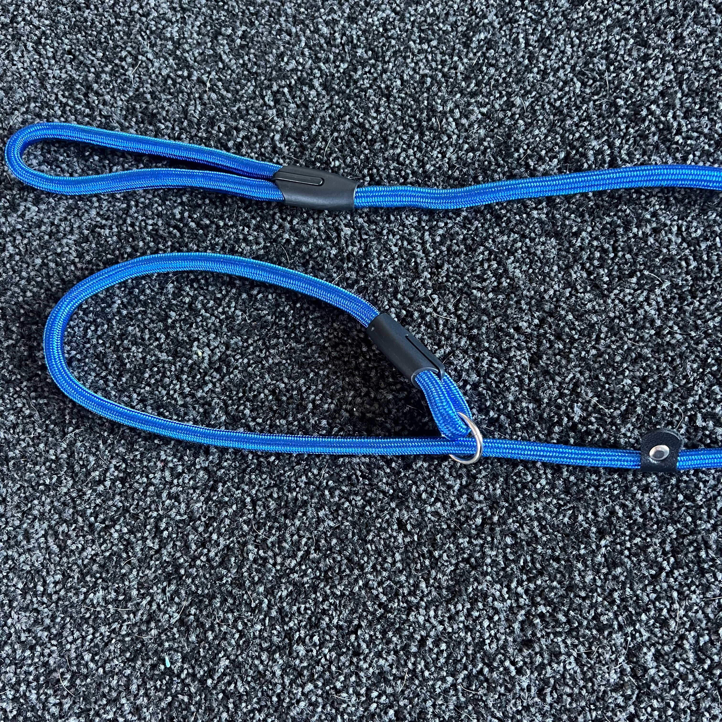 Blue Slip Leash with black connectors on a textured gray surface