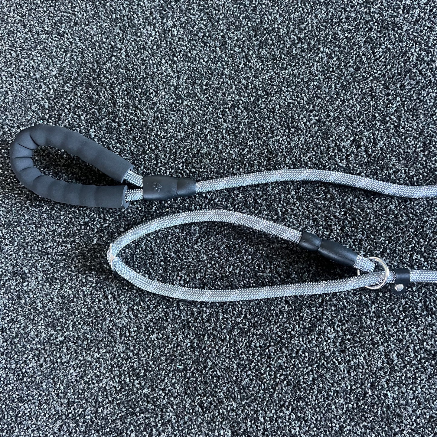 Black and gray dog leash on a textured black surface