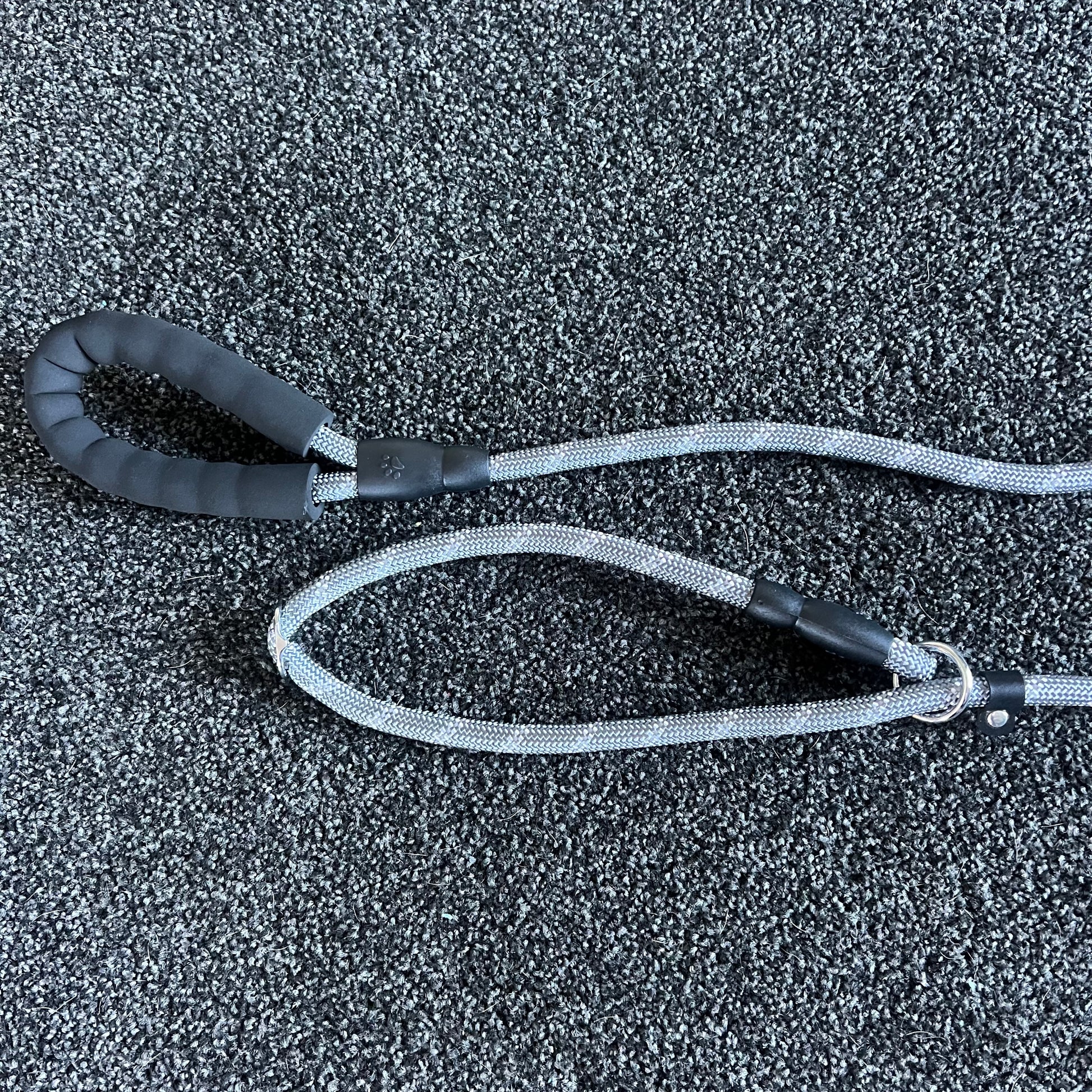 Black and gray dog leash on a textured black surface