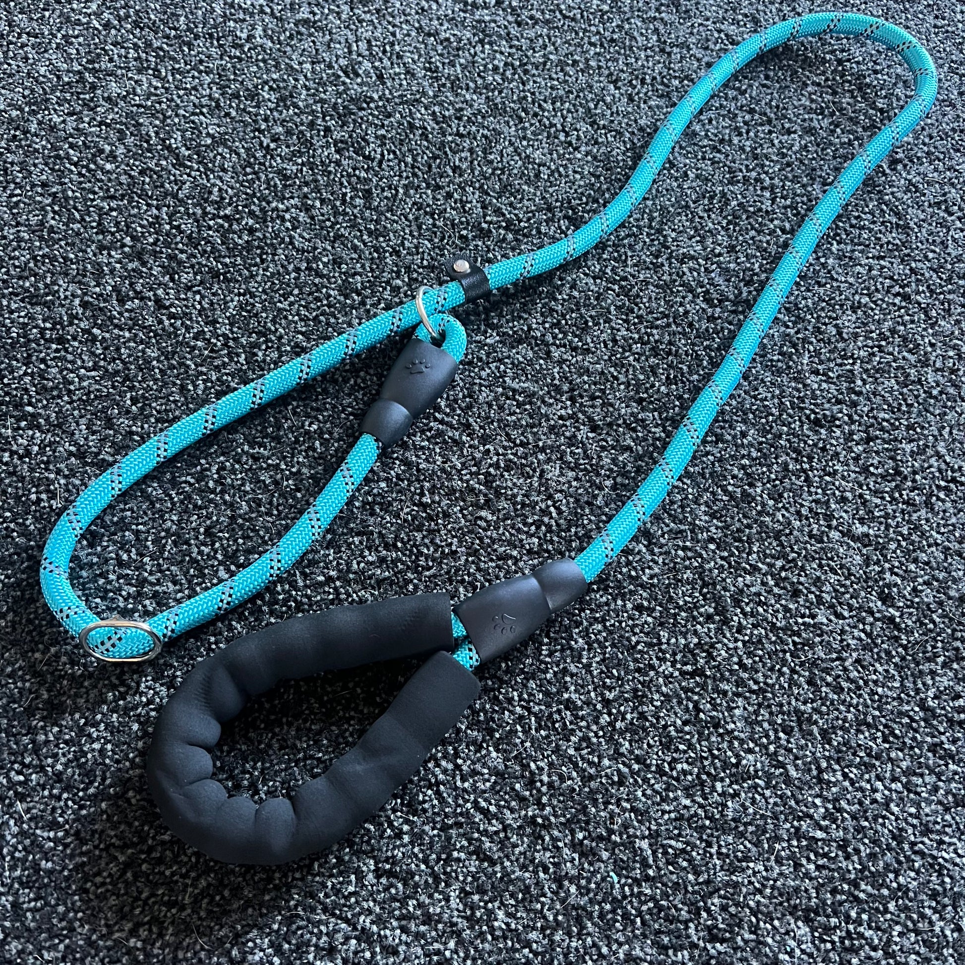 Blue and black dog leash on a textured gray surface