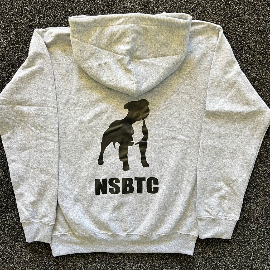 Gray hoodie with a black silhouette of a dog and 'NSBTC' text on the back, laid flat on a dark surface.