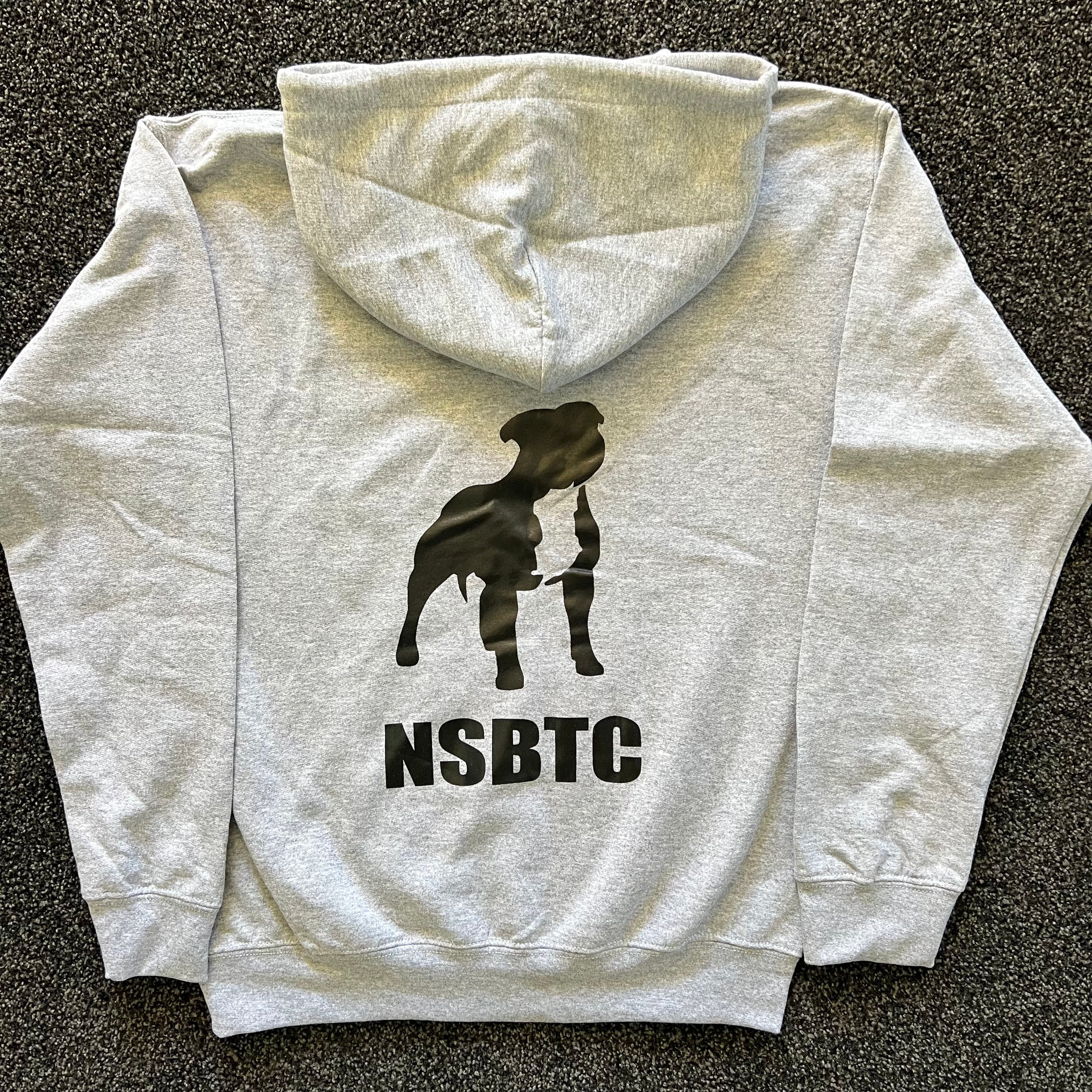 Gray hoodie with a black silhouette of a dog and 'NSBTC' text on the back, laid flat on a dark surface.