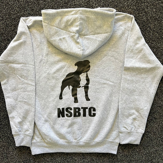 Gray hoodie with a black silhouette of a dog and 'NSBTC' text on the back, laid flat on a dark surface.