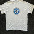 White t-shirt with a blue and black logo on a dark textured background