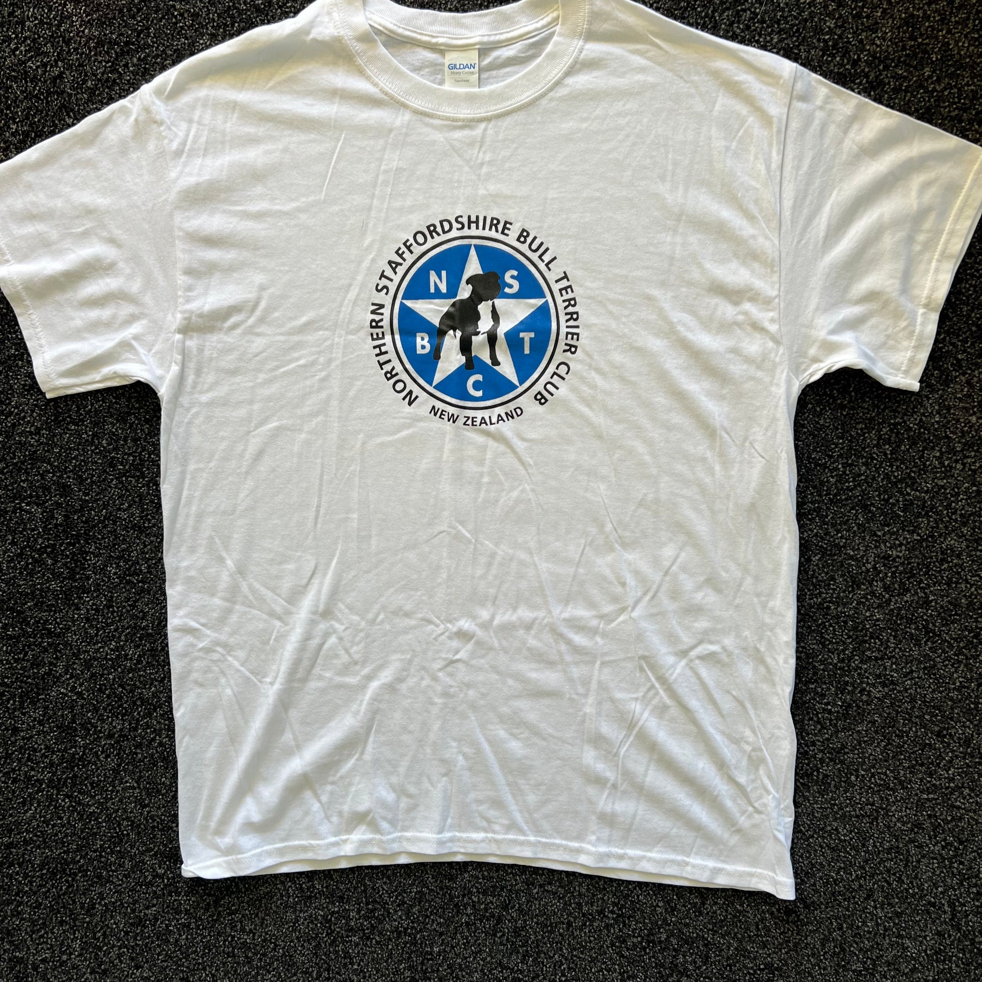 White t-shirt with a blue and black logo on a dark textured background