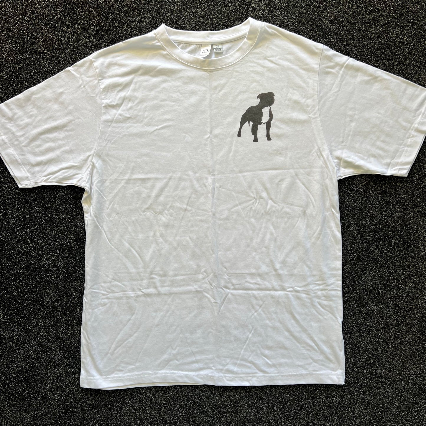 White t-shirt with a black silhouette design on a dark textured background