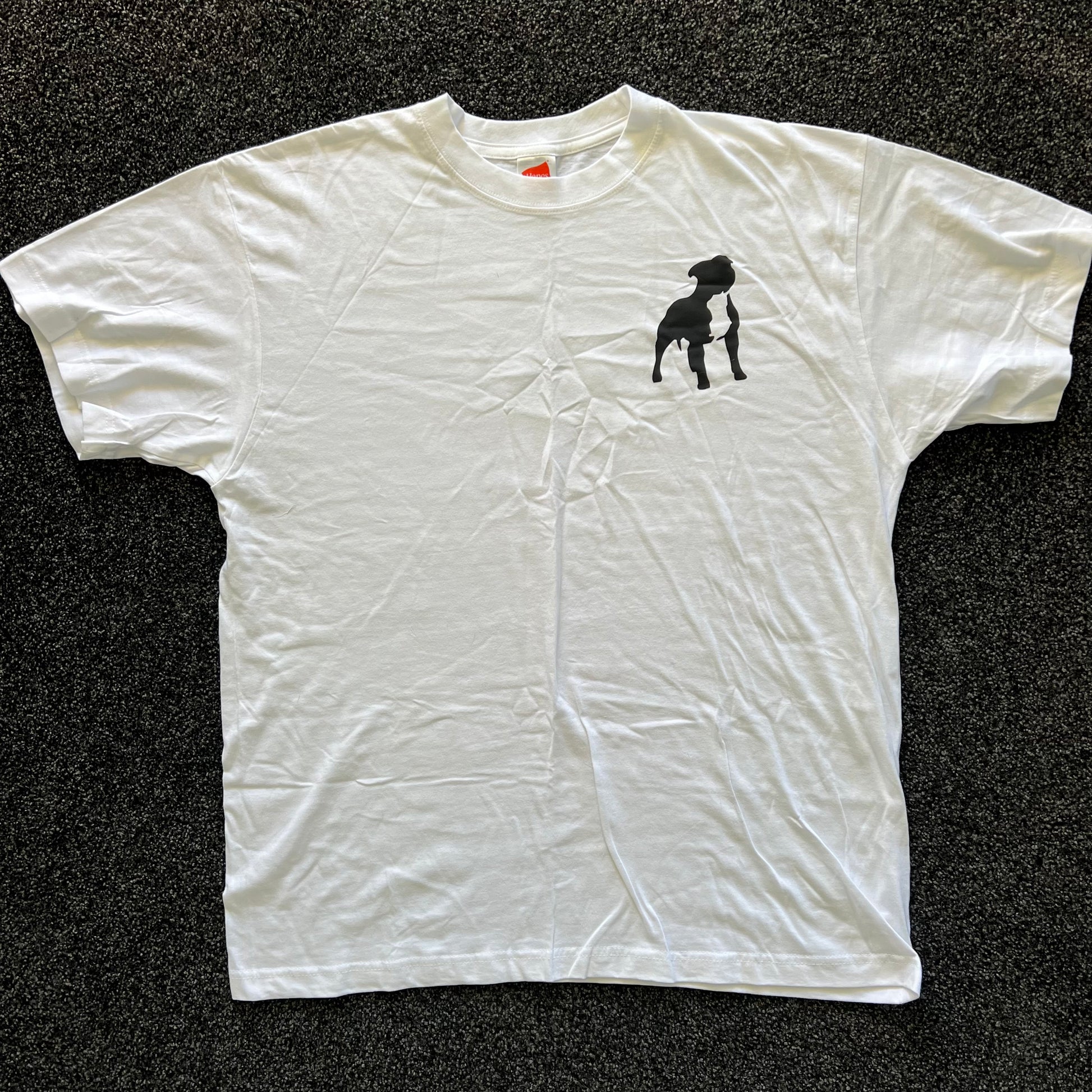 White t-shirt with a black dog graphic on a dark textured surface