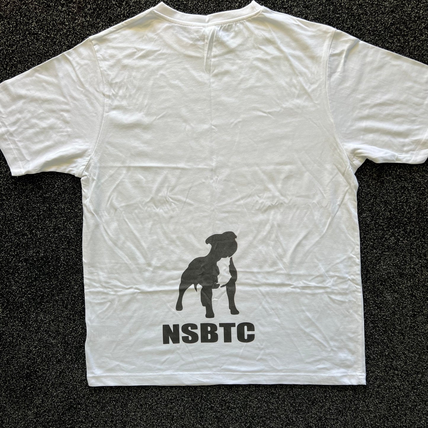 White t-shirt with a black silhouette and 'NSBTC' text on a dark textured background