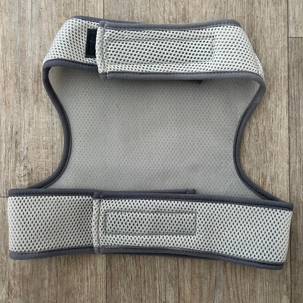 Grey mesh dog harness on a wooden floor